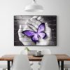 Purple Butterfly On Hand On Gray Wall